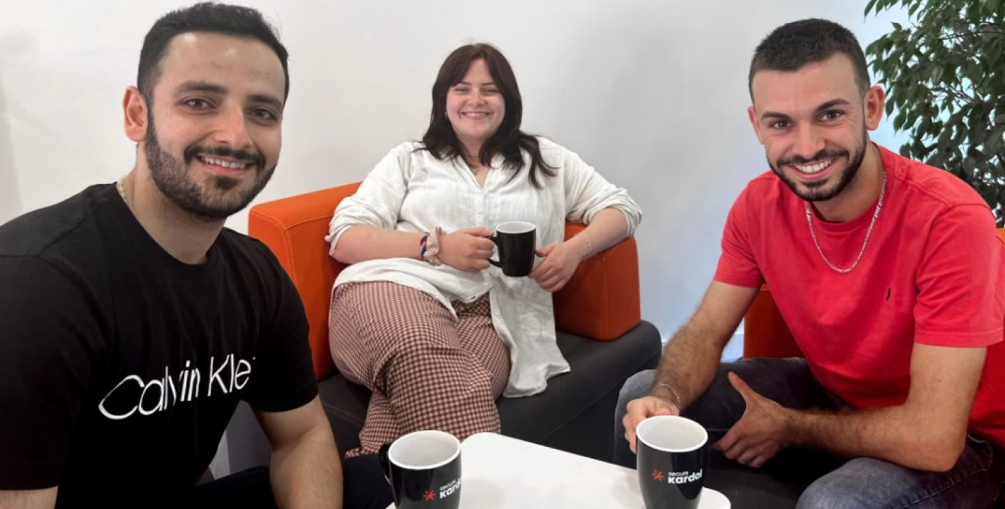 Trois collaborateurs souriants du Groupe Kardol prenant un café ensemble dans un espace détente