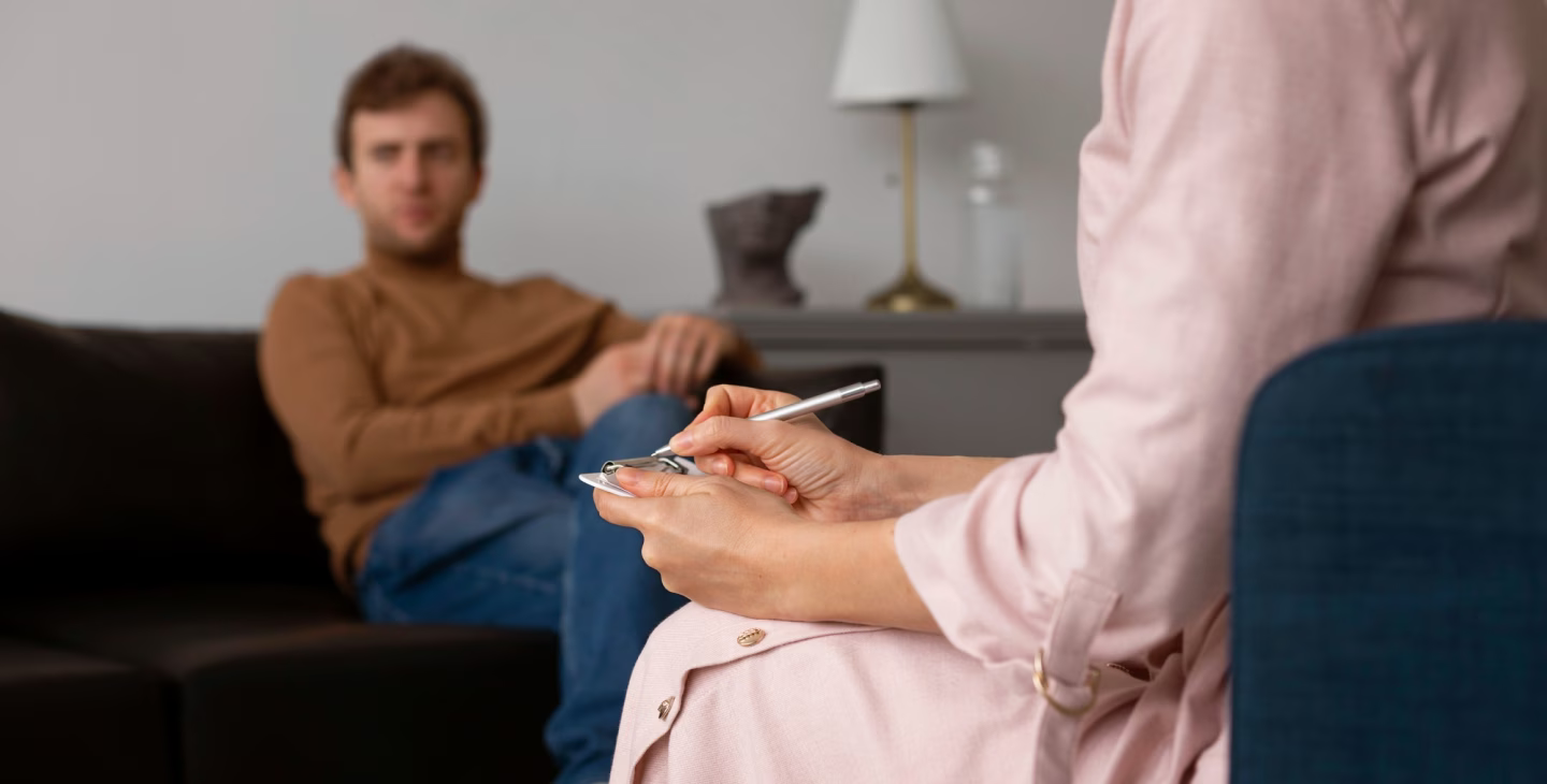 Une persone qui écoute une personne lors qu'un dispositif de soutien psychologique.