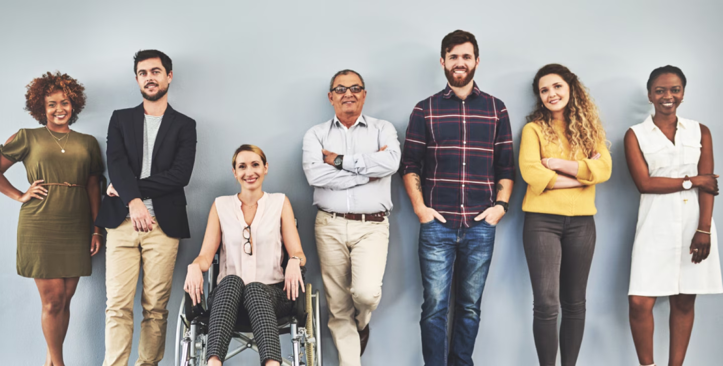 Groupe de personnes diverses avec une femme en fauteuil roulant, représentant la diversité et l'inclusion au travail.