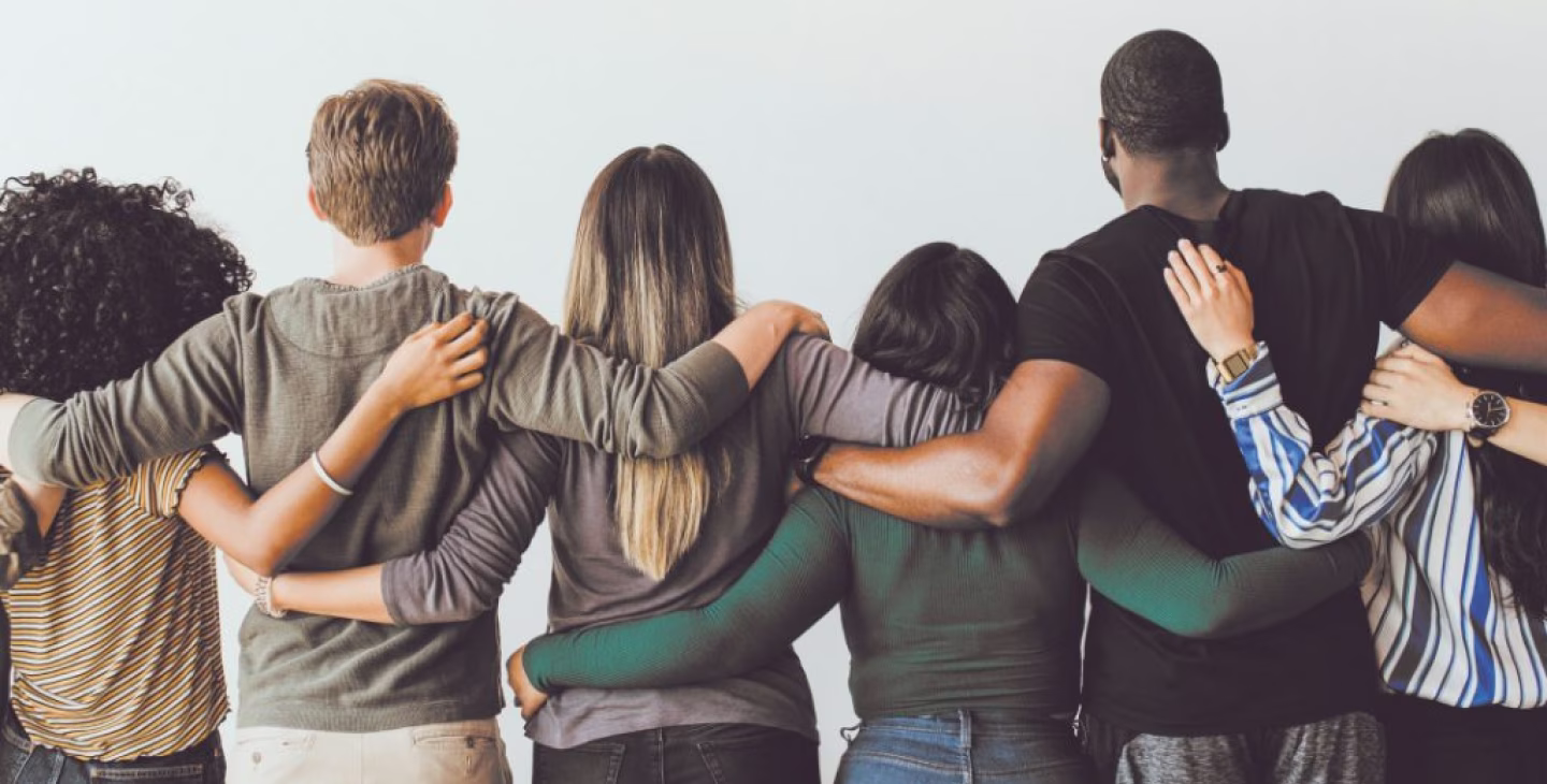 Équipe diverse de collaborateurs souriants travaillant ensemble dans un environnement professionnel inclusif