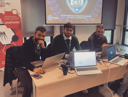 Trois participants installés avec leurs ordinateurs lors d’un forum